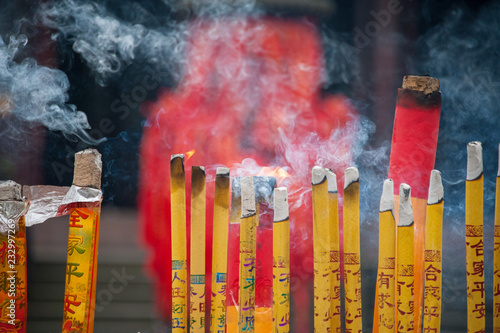 Incense candles burn in temple coutyard photo