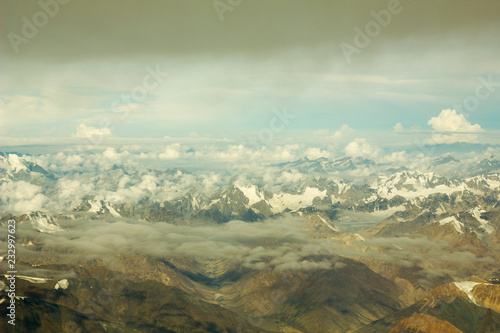 view of the mountain desert valley with snowy peaks and clouds from a height © Pavel
