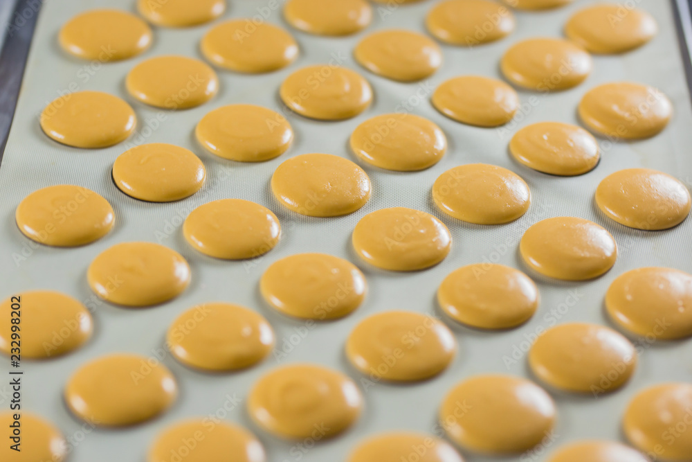 Macaroons on the film for vypikaniya. The process of cooking macaroon. Food industry, mass or volume production Macaroons on the film for vypikaniya. The process of cooking macaroon. Food industry, mass or volume production