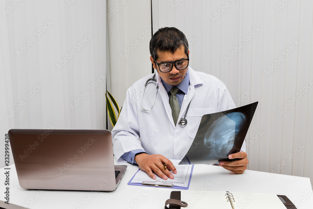 Doctor diagnose and analyze on x-ray film of patient. Doctor diagnose and analyze on x-ray film of patient.