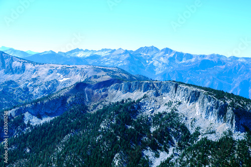 View from the top of the mountain or Olympus to the peaks on the background of clouds and blue sky © Dzmitry