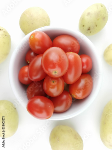 Cherry tomatoes and potato on white background