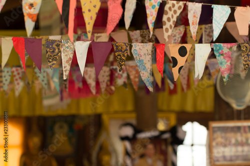 Soft focus of festival flags in door on poor lighting at temple in Thailand