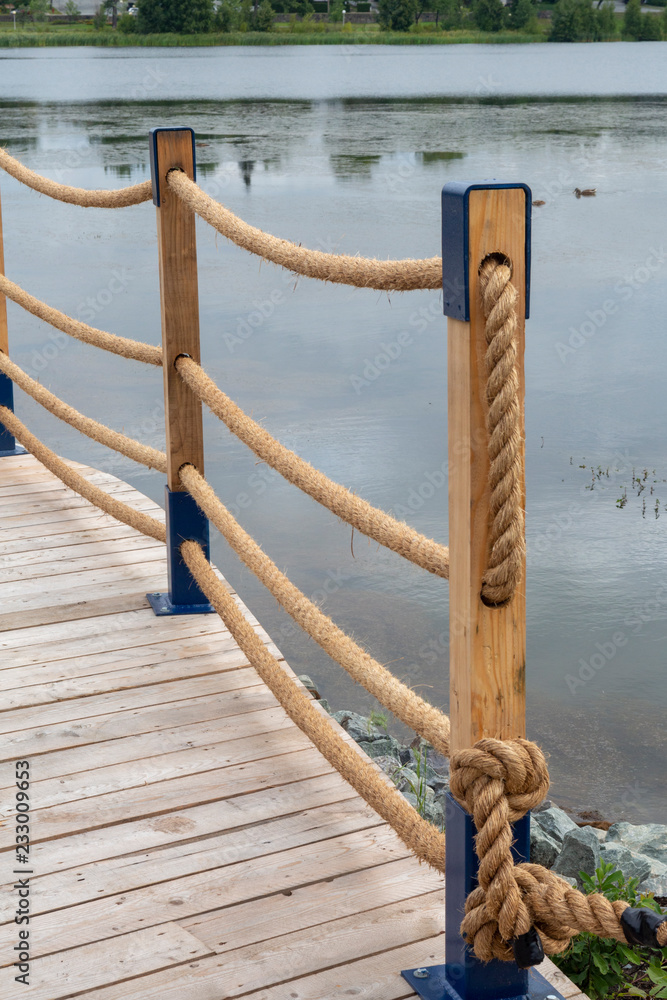 Obraz premium wood and rope railing on a boardwalk