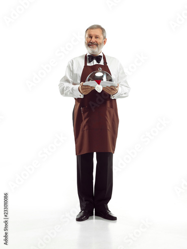 Senior waiter holding tray with Santa hat and standing isolated on white studio background. concept of good service and christmas, claus, happy holiday,