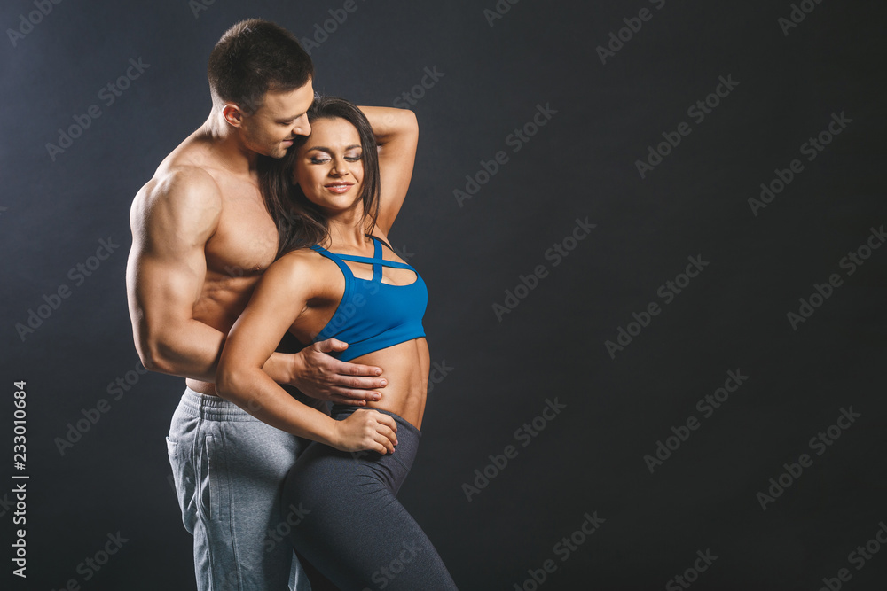 Sporty young sexy couple isolated over black background. Sporty young sexy couple isolated over black background.