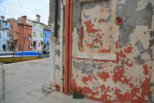 Insel Burano bei Venedig: Verwitterte Hausfassade mit Blick auf farbenfrohe Häuser an einem Kanal