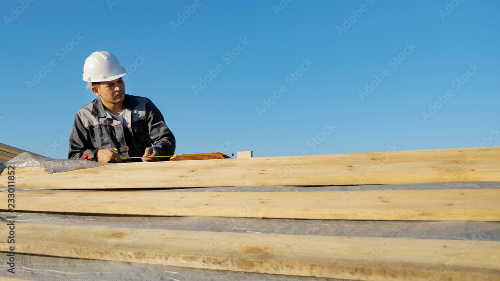 Man measuring lumber outdoors