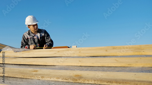 Man measuring lumber outdoors