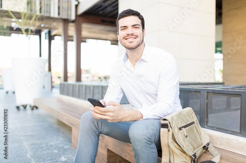 Businessman Smiling And Using Internet On Mobile Phone