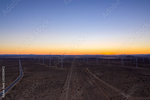 wind turbines in field at sunset