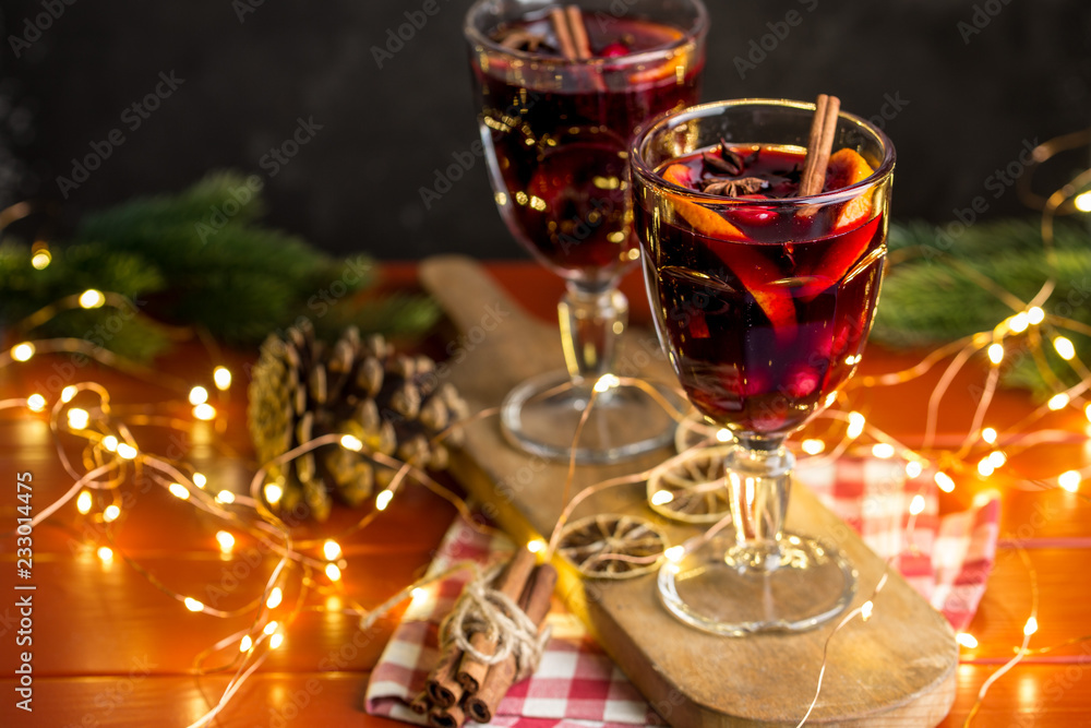 Christmas composition with spicy mulled wine, led lights and pine cones on dark background Christmas composition with spicy mulled wine, led lights and pine cones on dark background