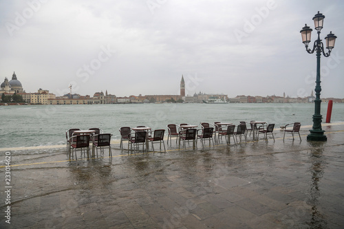 Venedig bei Hochwasser: Tische und Stühle eines leeren Restaurants Cafés im Wasser an der Fondamenta delle Zitelle (Giudecca) mit Blick auf die Stadtteile San Marco und Dorsoduro photo