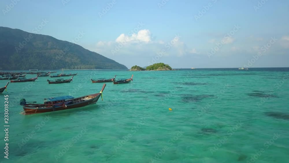Top of traditional Thai boats, white sand beach, beautiful clear emerald sea, aerial drone view on tropical island, Ko Lipe, Thailand. Top of traditional Thai boats, white sand beach, beautiful clear emerald sea, aerial drone view on tropical island, Ko Lipe, Thailand.