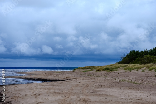 dirty beach by the sea with storm clouds above