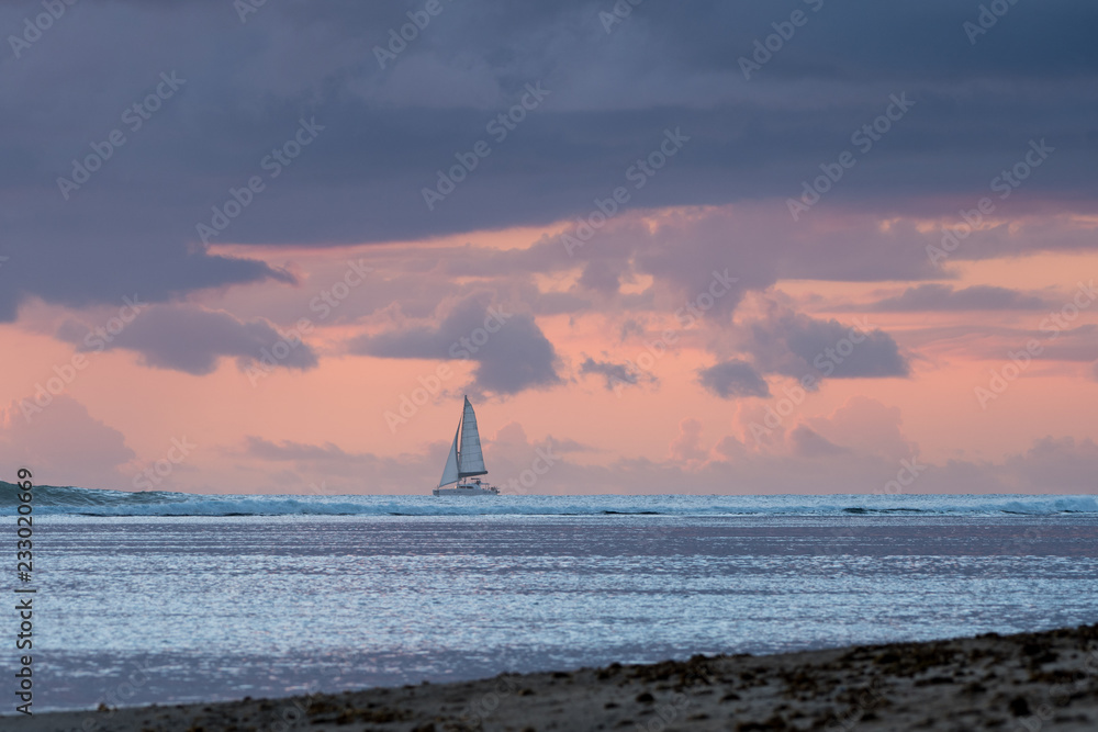 Φωτογραφία Sail boat out at sea with pink sky background