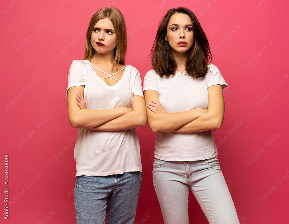 angry young two ladies standing over pink background angry young two ladies standing over pink background