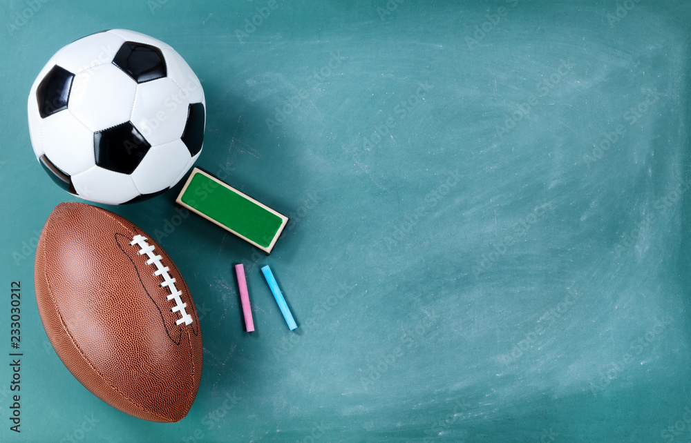 Φωτογραφία American football and soccer ball on cleaned chalkboard with writing supplies