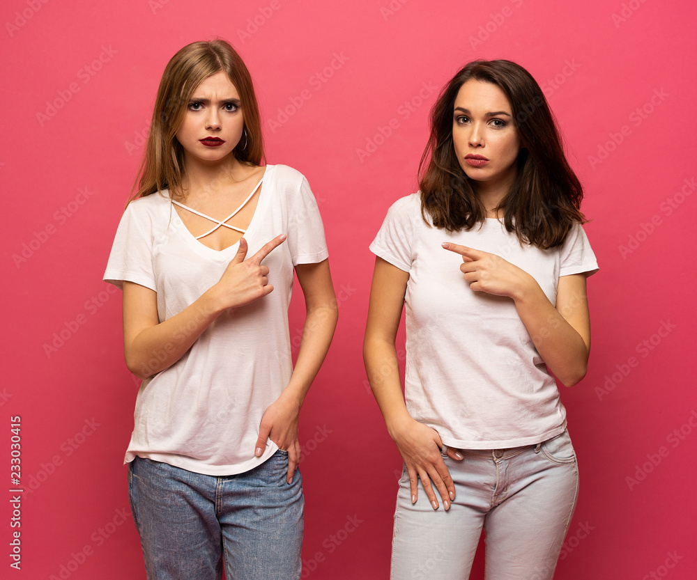 angry young two ladies standing over pink background angry young two ladies standing over pink background