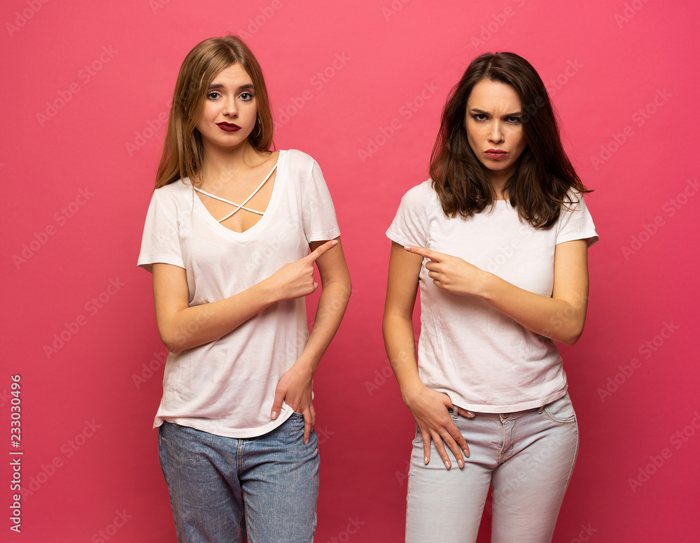 angry young two ladies standing over pink background angry young two ladies standing over pink background