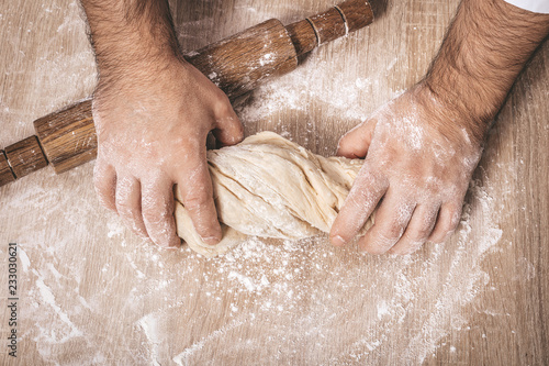 male chef kneads the dough