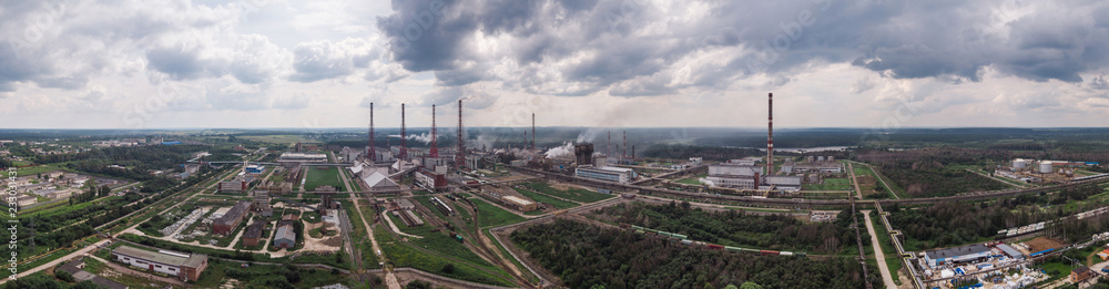 Industrial landscape. Panoramic view of the technological pipe and industrial infrastructure. Chemical production with red-white pipes and smoke is coming. Production buildings.