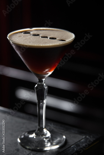 Espresso Martini cocktail on a bar desk. black background.