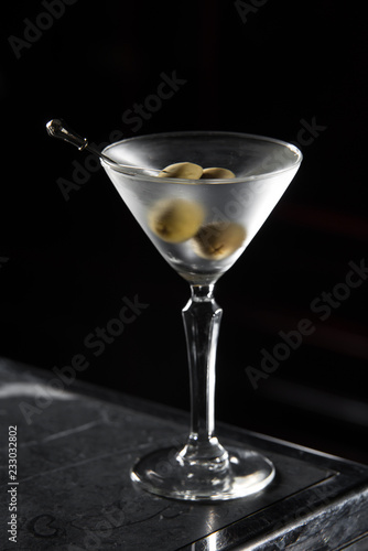 Dry Martini cocktail on a bar desk. black background