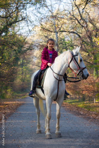 A girl rides a white horse in the forest © fotosr52