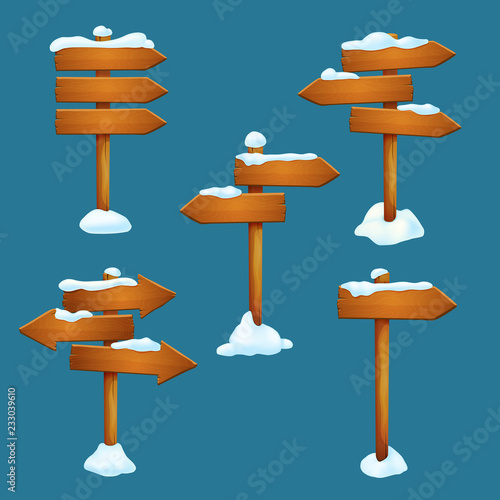Set of snow covered wooden signposts with arrow shaped planks pointing in different directions isolated on a blue background.