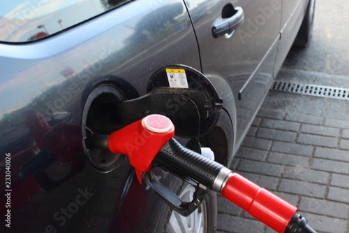 Refueling a car with fuel - a red refueling gun with 95 gasoline. Fuel business, oil, rise in price of gasoline