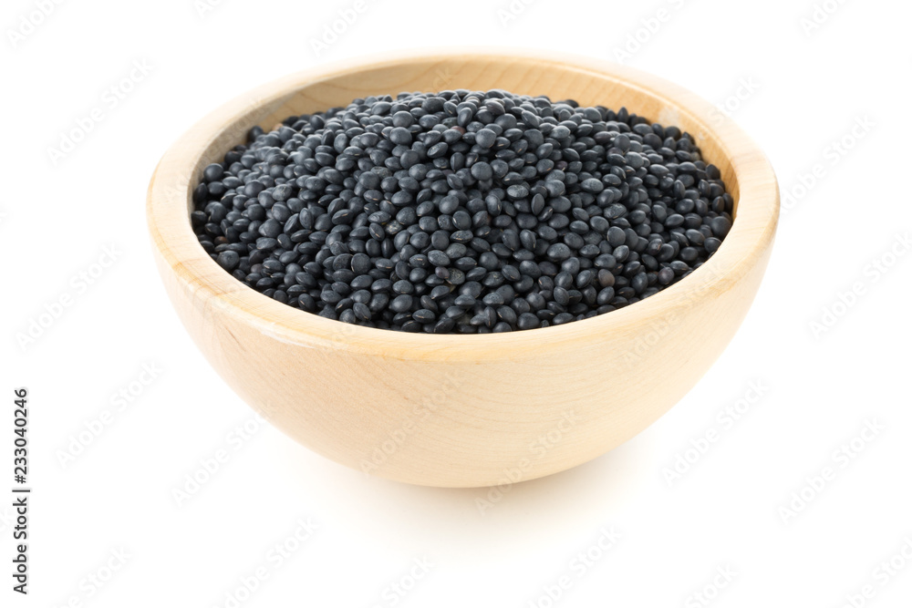 Heap of black organic beluga lentils in wooden bowl on white Heap of black organic beluga lentils in wooden bowl on white
