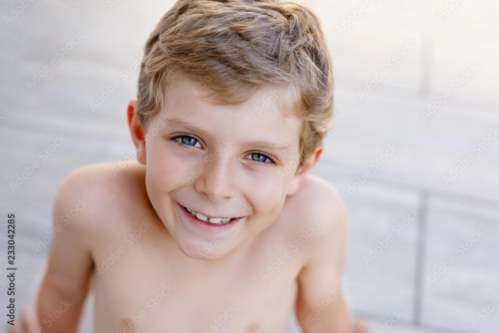 Beautiful Smiling Little Boy Portrait on warm sunny summer day. Happy kid looking at the camera. Adorable child with blond hairs and blue eyes Beautiful Smiling Little Boy Portrait on warm sunny summer day. Happy kid looking at the camera. Adorable child with blond hairs and blue eyes