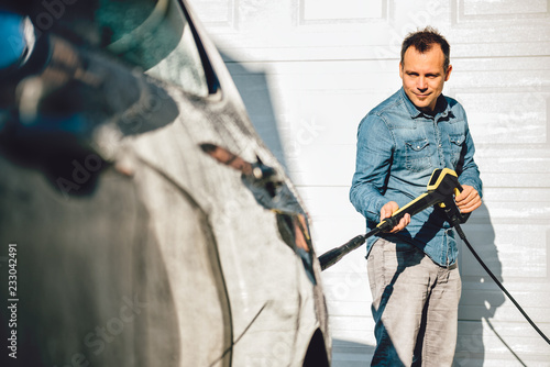 Men washing his car with pressure washer