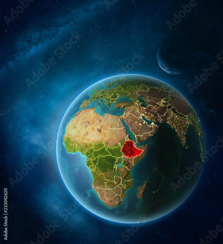 Fototapeta Naklejka Na Ścianę i Meble -  Planet Earth with highlighted Ethiopia in space with Moon and Milky Way. Visible city lights and country borders.