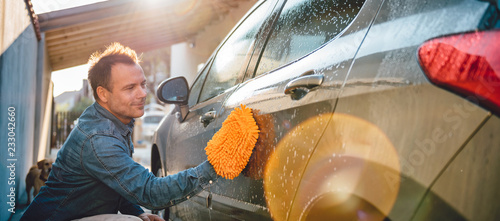 Men washing his car with wash mitt photo