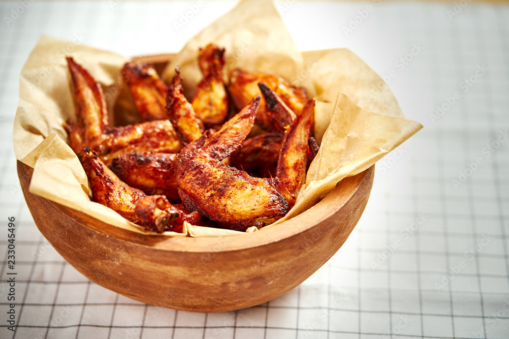 delicious fried chicken wings in a wooden bowl on a checkered tablecloth delicious fried chicken wings in a wooden bowl on a checkered tablecloth