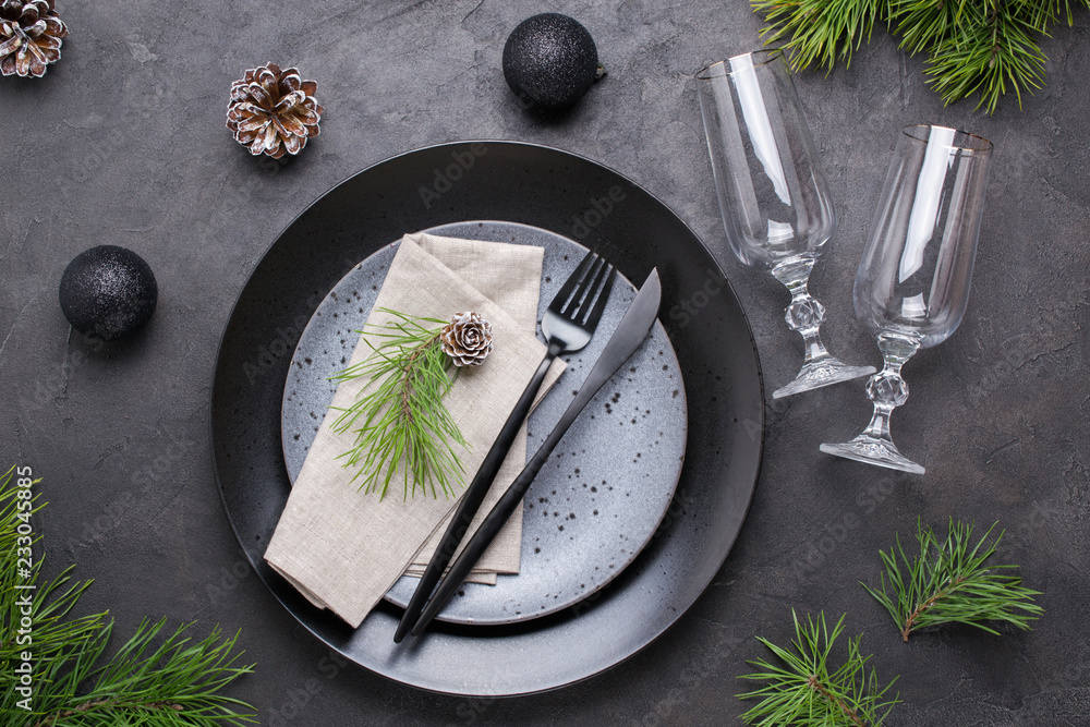 Dark christmas table setting design. Black plates, champagne glasses, fork  and knife set with napkin, fir branch, christmas decorations foto de Stock  | Adobe Stock