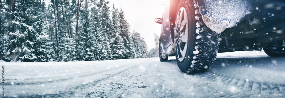 Fototapeta premium Zbliżenie opony samochodowe w zimie na drodze pokryte śniegiem