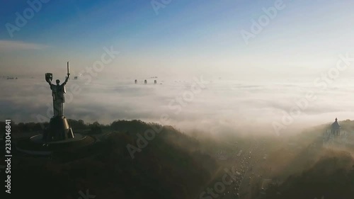 KKiev Ukraine The Motherland Monument USSR heritage. City hills on fog. Beautiful autumn morning. Aerial drone video footage. panoramic view. camera approaches and flies past photo