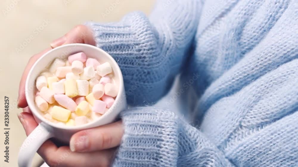 Girl hand with cup chocolate and marshmallows inside. Close up. Girl hand with cup chocolate and marshmallows inside. Close up.