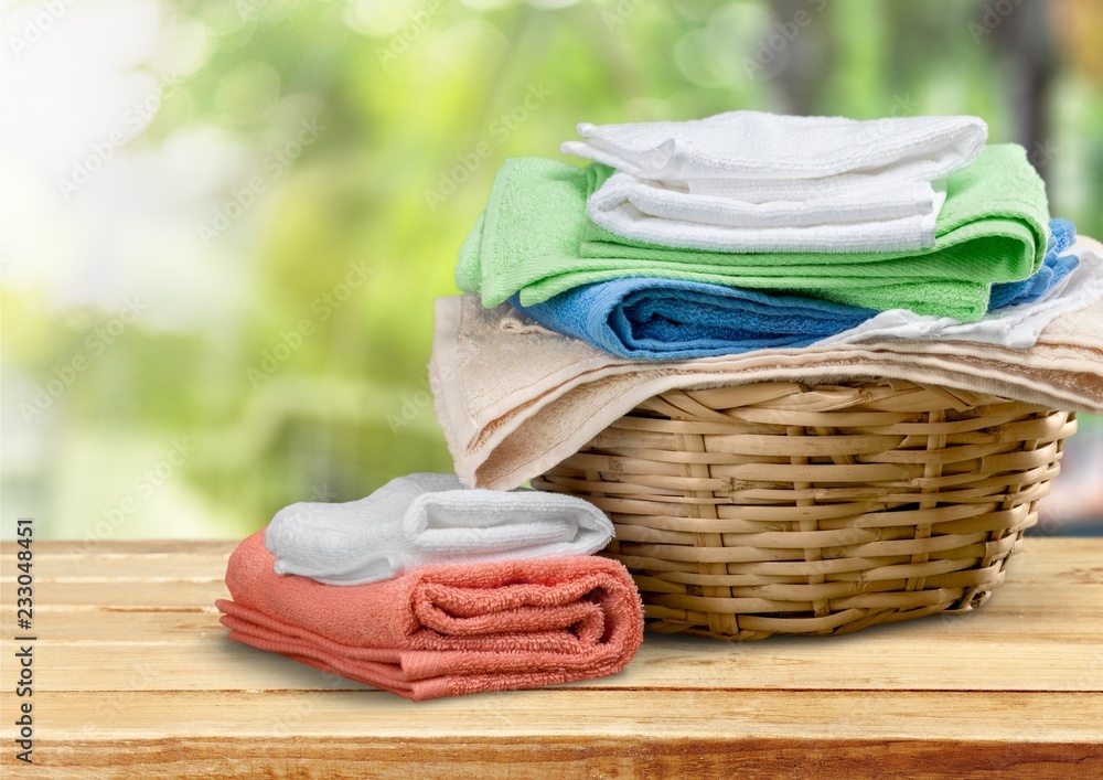 Laundry Basket with colorful towels on background Laundry Basket with colorful towels on background
