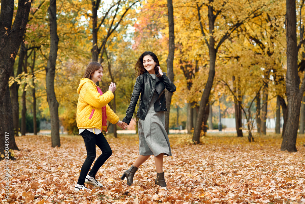 Two happy girls running in autumn city park. Two happy girls running in autumn city park.