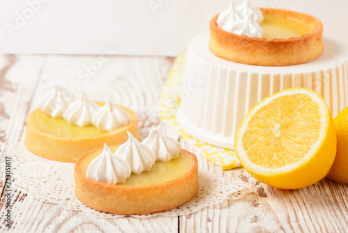 Lemon pie on the table with citrus fruits. Traditional french sweet pastry tart. Delicious, appetizing, homemade dessert with lemon curd cream. Copy space