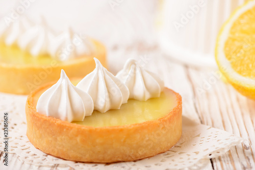 Lemon pie on the table with citrus fruits. Traditional french sweet pastry tart. Delicious, appetizing, homemade dessert with lemon curd cream. Copy space