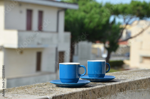 Two blue cups of coffee with panoramic view of a city in background. on the balcony against the backdrop of the old European city. good morning  romance