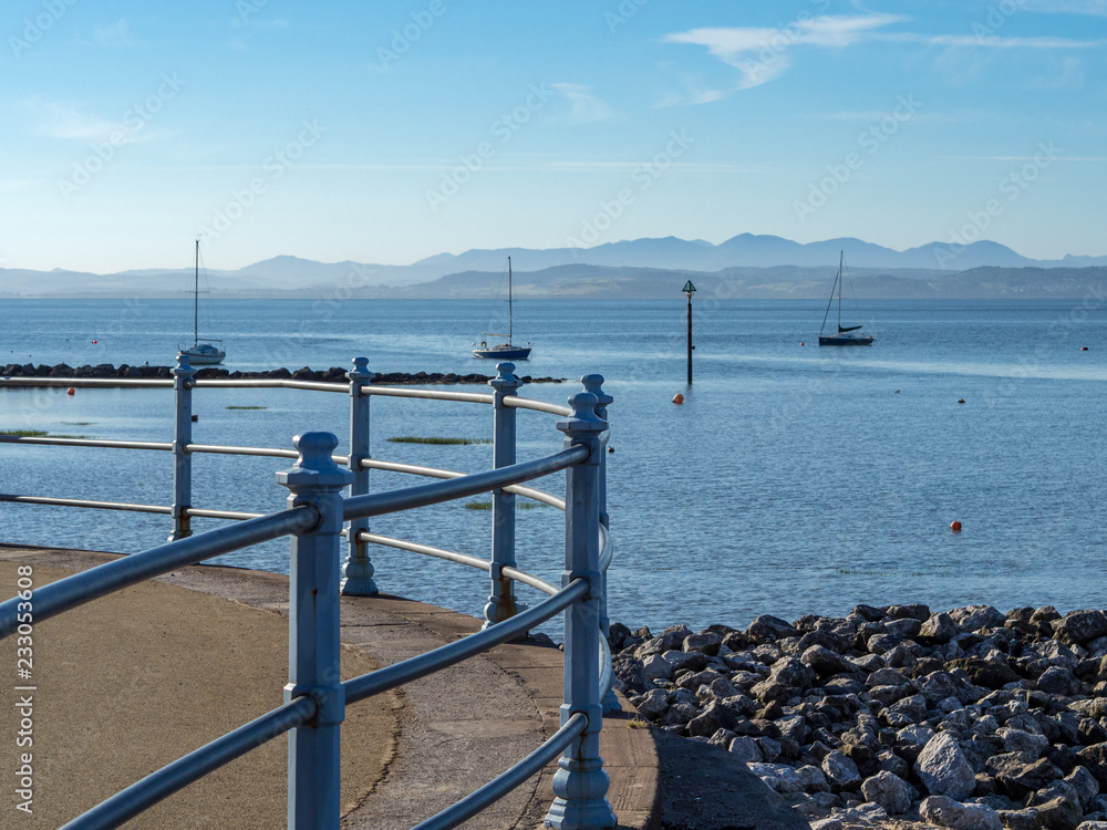 Boats in Morecambe Bay viewed from promenade with Lake District Hills in background