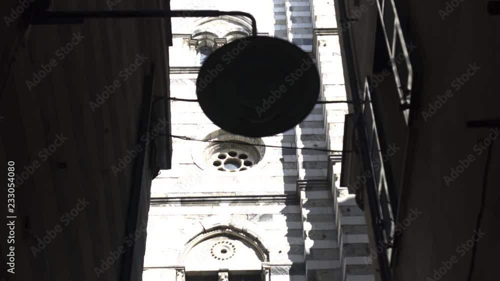 Street light hanging on the building wall, Narrow cozy street, Church tower in the background, Italy Street light hanging on the building wall, Narrow cozy street, Church tower in the background, Italy