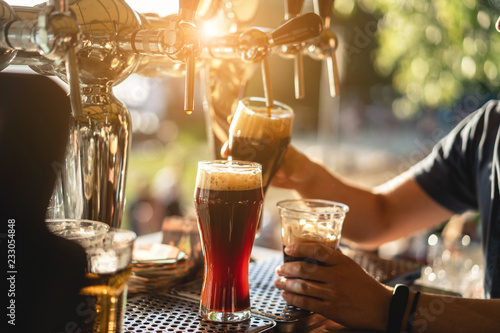 Foto bartender pours a dark beer close up