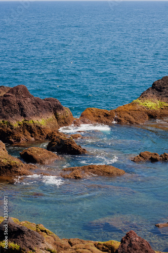 Natural lava pool. Funchal. Island Madeira. Portugal. Volcanic lava rocks separate the ocean and a calm natural swimming pool.